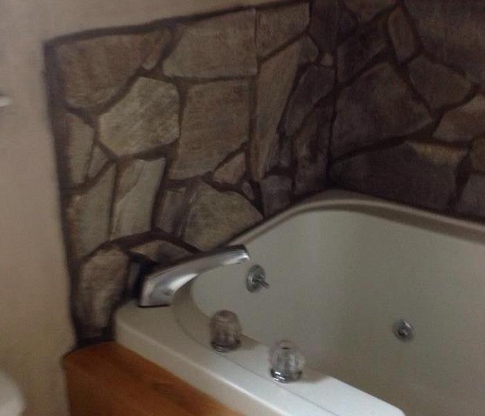 Stone work around the tub is covered with soot from a fire