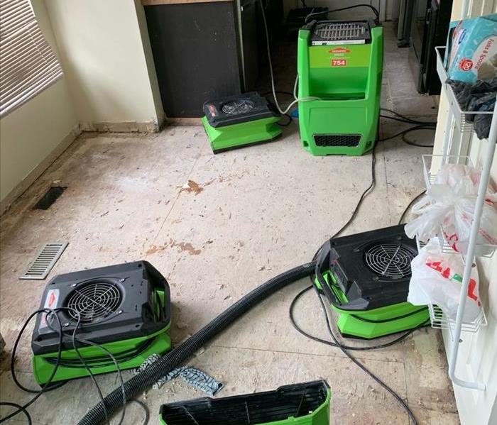 Green SERVPRO fans strategically placed in a kitchen flooded by a failed water line 