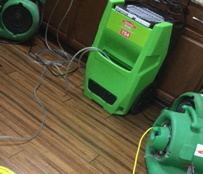 SERVPRO Green fans drying out a kitchen that suffered water damage