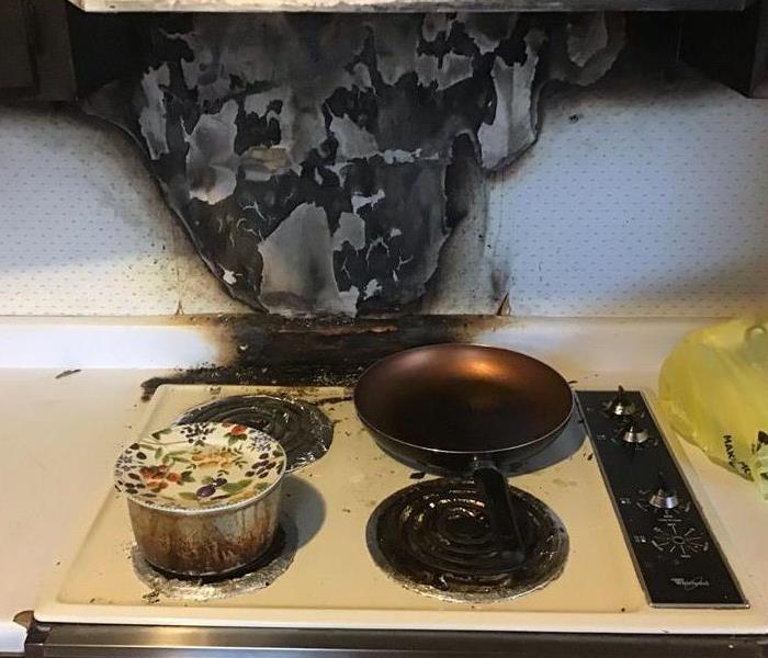 White stove that has suffered a fire due to no one attending the stove