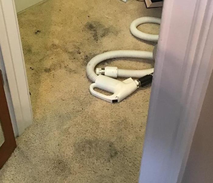 Cream colored bedroom carpet that has black footprints that are black with soot