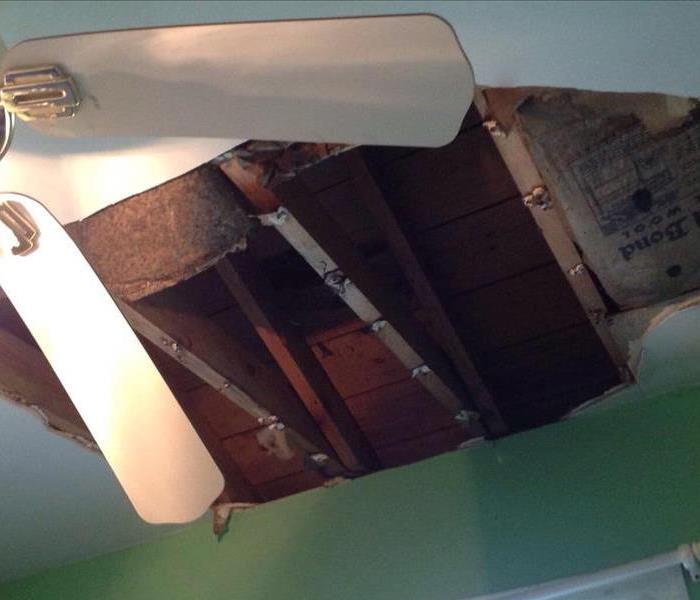 Ceiling fan and a large hole caused by a tree coming through the roof