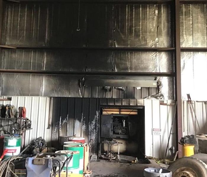 Interior of shop where a compressor was the cause of major fire damage.  Walls heavily affected with fire and smoke 