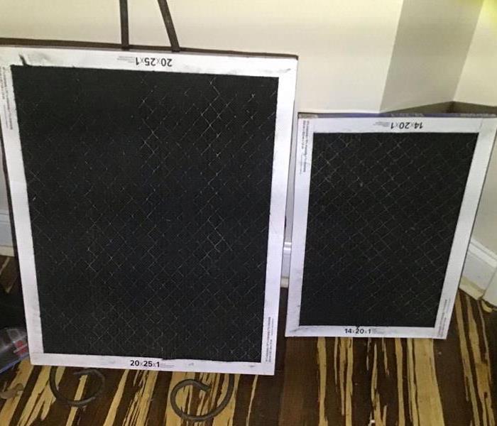 Two HVAC Filters that are all black from smoke at a residential fire