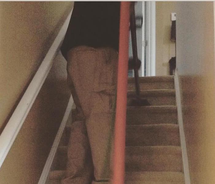 SERVPRO Technician Cleaning Carpet On Stairs