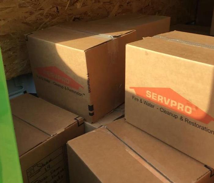 Green SERVPRO van packed with SERVPRO boxes of contents